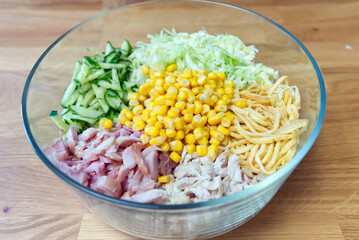 Nutritious vegetable salad with smoked chicken in a clear bowl. Ingredients are folded neatly not heremeshed. home food making