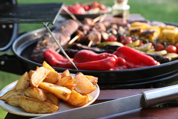 Tasty meat and vegetables on barbecue grill outdoors, closeup
