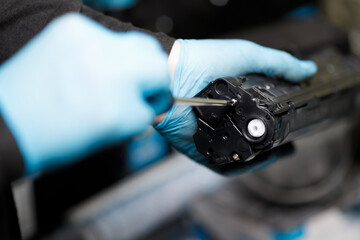 toner cartridge is disassembled with a screwdriver at a service center.