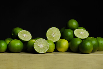 Green limes on the wooden table - 448603837