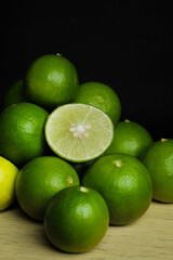Green limes on the wooden table - 448603841