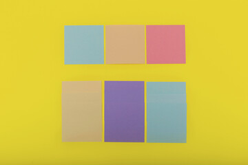 Colorful sticky notes on yellow background, flat lay