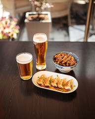 Japanese dishes gedza and katsudon chicken rice with beer on a table