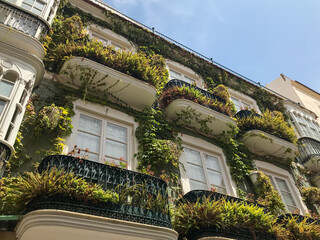 Facade of a building with balcony full of plants in Spain