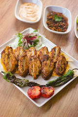 grilled chicken wings with vegetables, mezzes and salads on wooden table. turkish barbecue. 