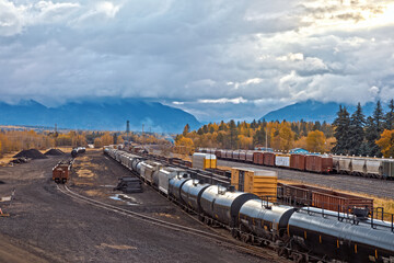 rail yard, Whitefish, Montana on a fall morning with heavy clouds and mountains in background