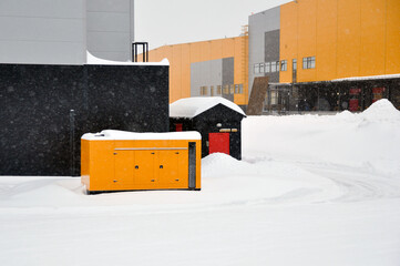 Mobile diesel generator on the territory of an industrial complex for emergency power supply in winter. - obrazy, fototapety, plakaty
