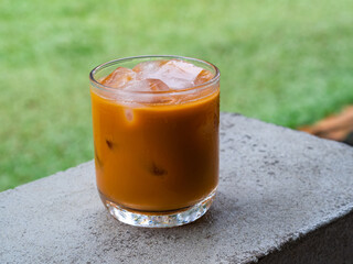 ice tea or ice thai tea in glass , fresh dessert in coffee cafe with nature background