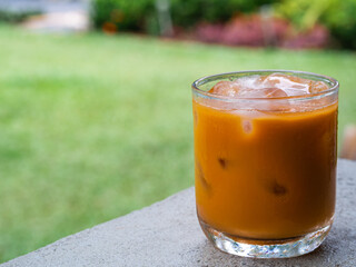 ice tea or ice thai tea in glass , fresh dessert in coffee cafe with nature background