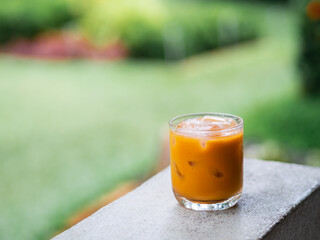 ice tea or ice thai tea in glass , fresh dessert in coffee cafe with nature background