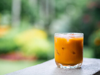 ice tea or ice thai tea in glass , fresh dessert in coffee cafe with nature background