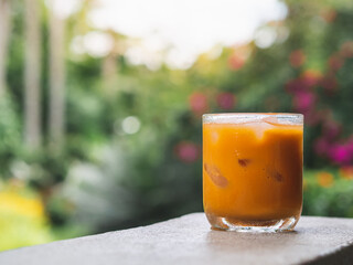 ice tea or ice thai tea in glass , fresh dessert in coffee cafe with nature background