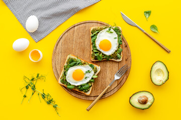 Toasts with eggs and avocado cream and spinach. Top view