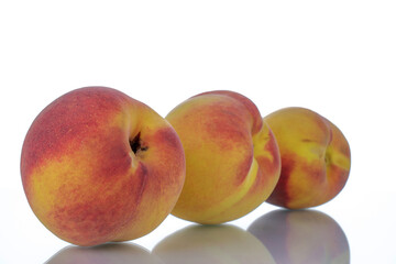 Three ripe peaches, close-up, isolated on white.