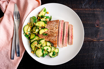 Tuna Steak with Cucumber-Peanut Salad: Rare fish fillet served with cucumber and peanut salad as a side dish