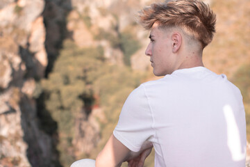 Adolescente de espaldas junto a la montaña posando