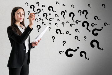 Portrait of attractive young european businesswoman with paperwork drawing abstract question marks...