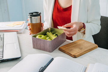 Female hands holding lunch zero waste box, food delivery box with healthy meal weight loss diet menu, vegan food at workplace in office. Office employee having vegan lunch at workplace