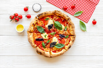 Cut into slices italian pizza with tomatoes cheese and basil