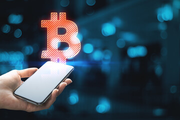 Close up of businesswoman hands holding phone with abstract glowing bitcoin sign on blue bokeh background with mock up place. Cryptocurrency and blockchain concept.