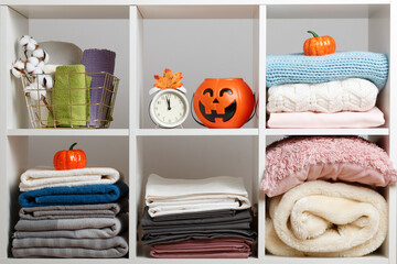 Bedding, towels, sheets on storage shelves for halloween celebration.