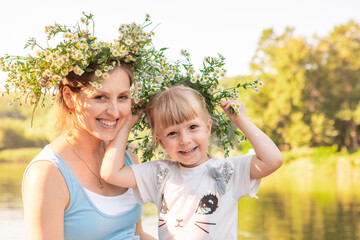 portrait of mother with daughter in chamomile wreath