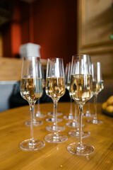 filled glasses of champagne on a wooden table in a cafe. the concept of the holiday.