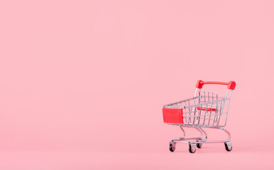 Shopping concept : Empty red shopping cart on pink background. online shopping consumers can shop from home and delivery service. with copy space