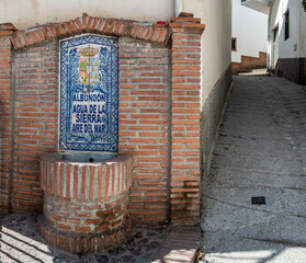 Fountain of the town of Albondón de Granada made of Granada ceramics and red brick next to a steep...