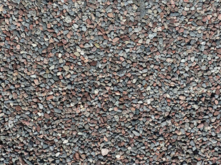 Wide view from above of many gravel pebble stones, pattern outdoors.