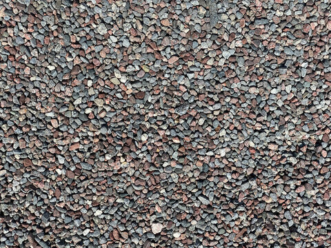 Wide view from above of many gravel pebble stones, pattern outdoors.