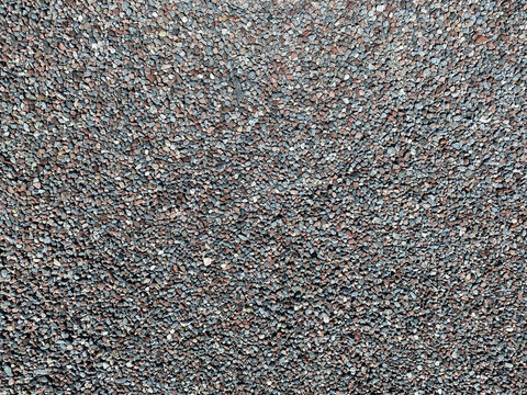 Wide view from above of many gravel pebble stones, pattern outdoors.