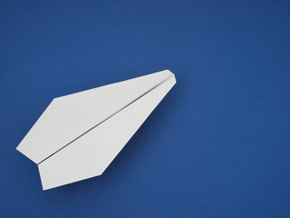 Flat masonry of white paper plane on a pastel blue background