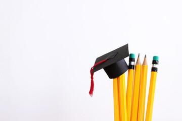 Image of education concept. Traditional graduation hat over pencils