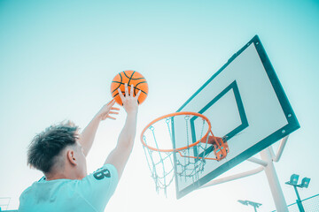 Jugador de baloncesto canastando el balón en la pista de juego para ganar puntos