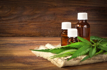 Hemp oil bottles, hemp leaves on canvas. Medical cannabis concept.    