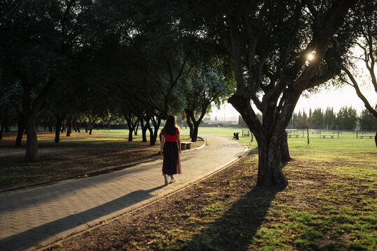 Stylish woman standing on path meadow in park