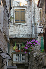 Fototapeta na wymiar The balcony with the flower pots at the stone street of Trogir town, Trogir, Croatia