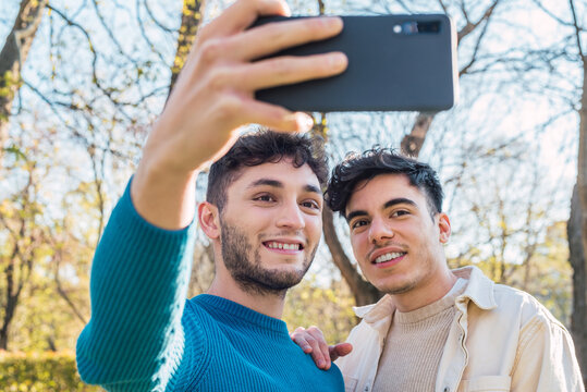 Happy gay couple taking selfie on smartphone