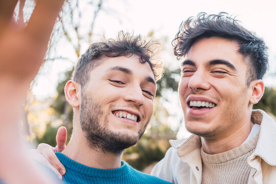 Happy LGBT couple of men taking selfie in park