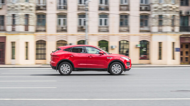 Jaguar E-Pace X540 is driving on high speed in front of classic vintage building