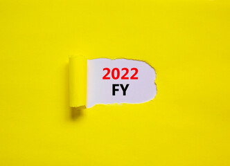 2022 FY fiscal new year symbol. Words '2022 FY fiscal year' appearing behind torn yellow paper. Beautiful yellow background. Business, 2022 FY fiscal new year concept, copy space.