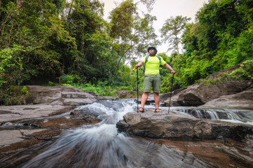 Tourist Travelers with backpack to travel Waterfall in Khao Yai National Park, Thailand UNESCO World Heritage Area. tourist trekking to waterfall in tropical forest during holiday. Holiday activities.