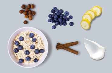 Creative concept still life health diet food photo of bowl dish with healthy breakfast oatmeal corn flackes fruits berries blueberry banana  yoghurt on grey background..