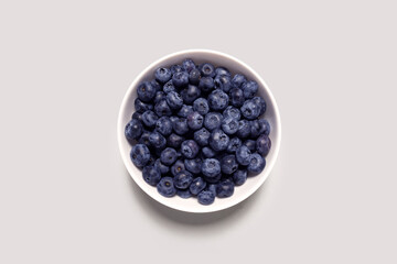 Creative food health diet concept photo of plate dish bowl with blueberry on grey background..