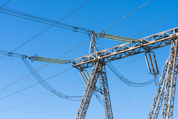 Fototapeta premium a line of high-voltage wires on a blue sky background