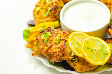 Delicious onion bhaji fritters served on ceramic plate with white dip