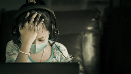 Little girl sit online studying with stress until she has a headache.Concept of online learning problem