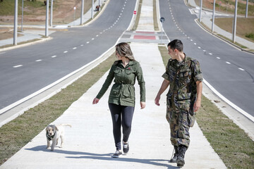 Casal passeando com cachorro Golden retriever com roupa militar retro.