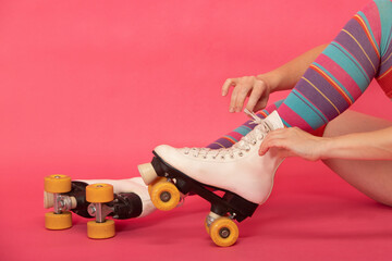 woman's hands tying the laces of her retro skate boots